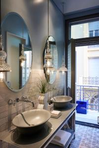 a bathroom with two sinks and two mirrors at Hotel Fresh in Athens
