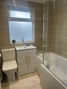 a bathroom with a toilet and a sink and a shower at 1 bedroom modern house near hospital with parking in Southampton