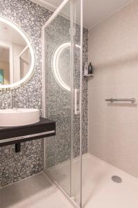 ein Bad mit einer Dusche und einem Waschbecken in der Unterkunft ibis Styles Bredene in Bredene