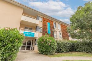 un edificio con un cartel en el costado en Appart'City Classic Toulouse Tournefeuille, en Tournefeuille