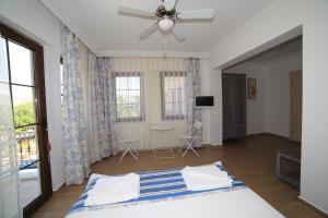 a bedroom with a bed and a table and windows at Mavi Deniz Konuk Evi in Selimiye