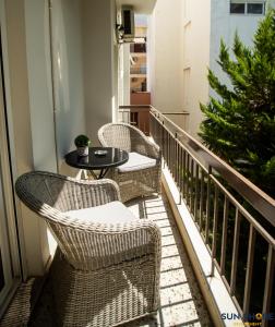 balkon z 3 krzesłami, stołem i choinką świąteczną w obiekcie Explore Greece from Comfortable City Centre Apartment w Chalkidzie
