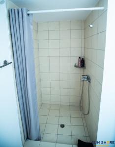 La salle de bains est pourvue d'une douche avec rideau de douche. dans l'établissement Explore Greece from Comfortable City Centre Apartment, à Chalcis