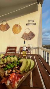 einen Holztisch mit einem Teller Essen und einer Flasche Wein in der Unterkunft NIEUW: Bello Horizonte, house by the sea in Torremolinos