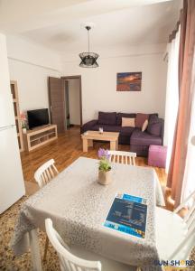 een woonkamer met een tafel en een bank bij Explore Greece from Comfortable City Centre Apartment in Chalkida