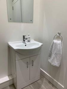W białej łazience znajduje się umywalka i lustro. w obiekcie Platform Church View Apartment Hull w mieście Hedon