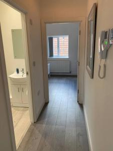 a hallway of a bathroom with a sink and a mirror at Platform Church View Apartment Hull in Hedon