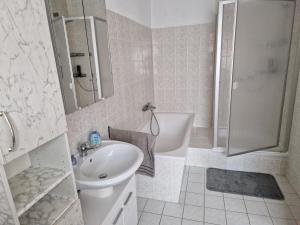 y baño blanco con lavabo y ducha. en Ferienwohnung/Monteurunterkunft Leopolshall en Staßfurt