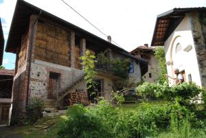 una vecchia casa con portico e balcone di Agriturismo I Sette Raggi ad Ailoche