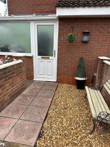 a bench in front of a house with a door at 1 bedroom modern house near hospital with parking in Southampton