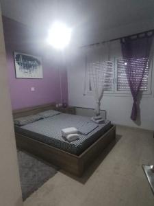 una camera da letto con un letto e due asciugamani di Alex apartments relax a Agia Marina Mikrolimanou