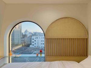 a bedroom with a large window with a view of a city at Exclusive Penthouse with Great Hanok Village View in Seoul