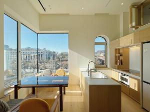 a kitchen with a sink and a large window at Exclusive Penthouse with Great Hanok Village View in Seoul