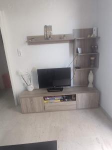 ein Entertainment-Center mit einem TV im Wohnzimmer in der Unterkunft Alex apartments relax in Agia Marina Mikrolimanou