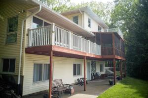 a house with a deck on the side of it at Finn's Hideaway -Modern family river home in Keokuk