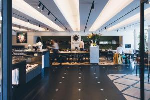 a restaurant with people sitting at tables in a room at Golden Tulip Hotel Central in Den Bosch