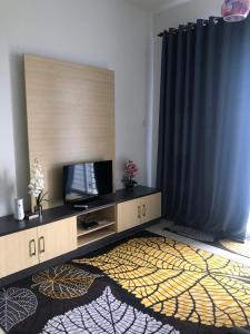 - un salon avec une télévision et un rideau dans l'établissement HOMESTAY DOABONDA, à Kajang