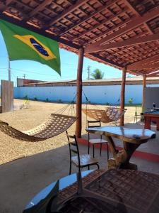 een patio met een tafel en stoelen en een vlag bij POUSADA ALÉM-K in Riachão