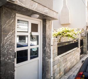 una porta bianca sul lato di un edificio di Explore Greece from Apartment with Private Garden a Calcide