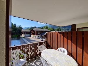 eine Terrasse mit einem Tisch und Stühlen auf dem Balkon in der Unterkunft Bel appartement avec piscine - Le Grand Tétras in Samoëns