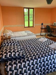 Beaubec-la-RosièreにあるChambres d'hôtesのベッドルーム1室(ベッド2台、窓付)