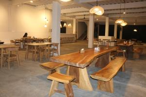 un ristorante con panche, tavoli e sedie in legno di Vogelkopf Resort a Tapokreng