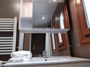 uma casa de banho com um lavatório e um espelho sobre o lavatório em Hôtel L'Oustalet em Font Romeu Odeillo Via