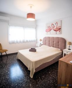 una camera con un grande letto con testiera rosa di Explore Greece from Apartment with Private Garden a Calcide