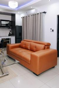 a brown leather couch sitting in a living room at The Lofts Luxury Suites in Windhoek