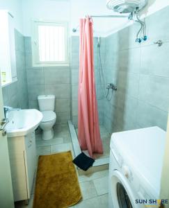 bagno con lavandino e servizi igienici e lavatrice. di Explore Greece from Apartment with Private Garden a Calcide