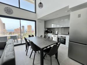 a kitchen and dining room with a table and chairs at Beautiful duplex modern apartment in Calpe - Inmodream Calpe in Ifach