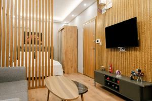 een woonkamer met een televisie aan een houten muur bij Compact Flat 2 min to Metro, Near Marmara Park in Istanbul