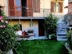 Brosso的住宿－La casa di Elma，庭院,带长凳和鲜花的房子