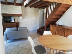 ein Wohnzimmer mit einem Tisch und einem Sofa in der Unterkunft La petite maison in Matha