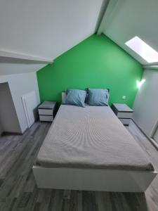 ein Schlafzimmer mit einem Bett mit einer grünen Wand in der Unterkunft Fontaine Vieille in Saint-Georges-de-Luzençon