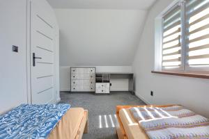 a small bedroom with a bed and a window at Domki w Zielonym Gaju in Ustrzyki Dolne