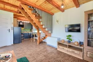 a living room with a staircase and a kitchen at Domki w Zielonym Gaju in Ustrzyki Dolne