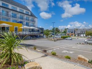 an empty parking lot in front of a building at L'Escale Marine, The Originals Relais in Crozon