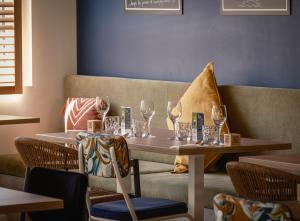 a table with wine glasses on it next to a couch at L'Escale Marine, The Originals Relais in Crozon