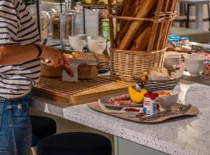 a person pointing at a plate of food on a counter at L'Escale Marine, The Originals Relais in Crozon