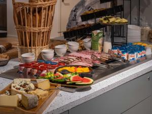 a buffet with meats and other foods on a counter at L'Escale Marine, The Originals Relais in Crozon
