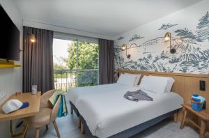a hotel room with a large bed and a window at L'Escale Marine, The Originals Relais in Crozon