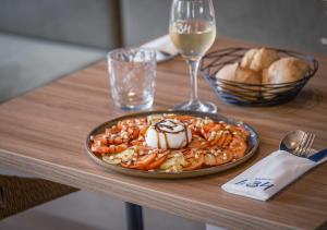 a plate of food on a table with a glass of wine at L'Escale Marine, The Originals Relais in Crozon