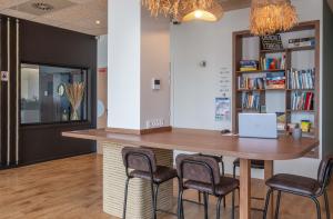a bar in a room with chairs and a desk at L'Escale Marine, The Originals Relais in Crozon