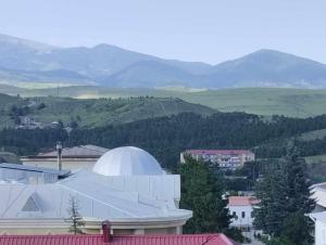 um observatório branco com montanhas ao fundo em Meskheti Tower Unit 93 em Akhaltsikhe