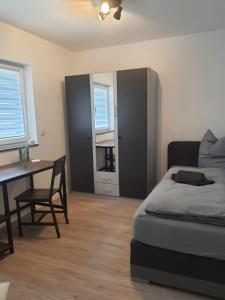 een slaapkamer met een bed, een bureau en een tafel bij ADAM Gästehaus in Sülzetal