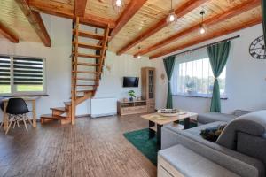 a living room with wooden ceilings and a spiral staircase at Domki w Zielonym Gaju in Ustrzyki Dolne