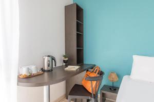a small desk in a room with a bed at Appart'City Classic Toulouse Tournefeuille in Tournefeuille