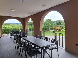 a patio with tables and chairs and a view of a playground at Posestvo Rouna - winery and apartments in Vipava