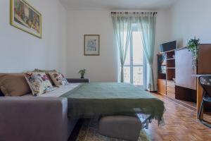 都靈的住宿－Little Peschiera by Wonderful Italy，客厅配有床和沙发